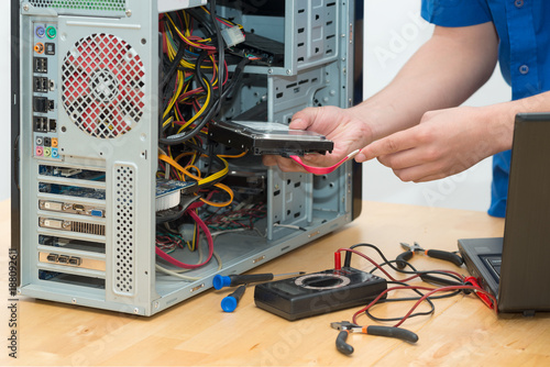 Картината върху платно Young technician working on broken computer in his office