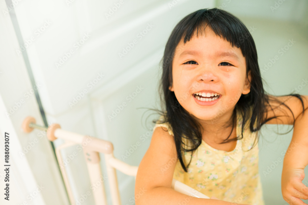 little girl crying and smile when she stuck on safety gate on door.Baby protect fence,Stair gate. little girl crying and smile when she stuck on safety gate on door.Baby protect fence,Stair gate.