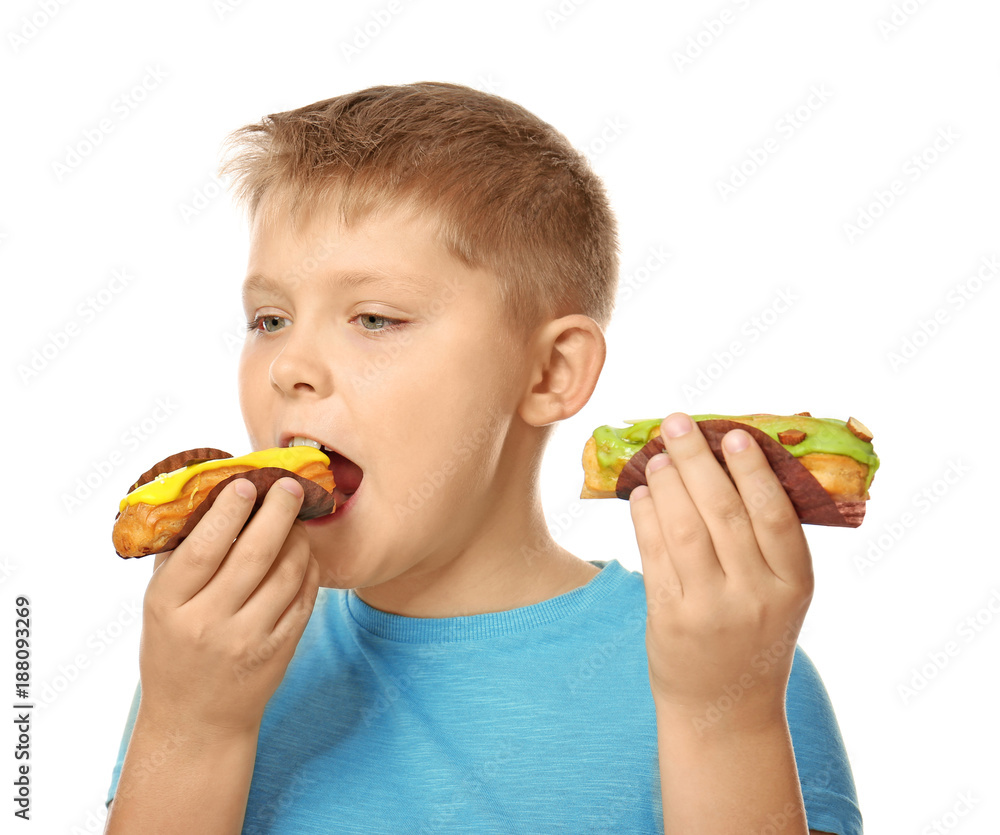 Overweight boy eating eclairs on white background Overweight boy eating eclairs on white background