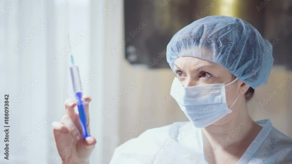 Young woman doctor with mask prepares a syringe on x-ray background. Medical concept. Young woman doctor with mask prepares a syringe on x-ray background. Medical concept.