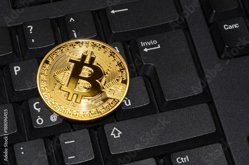 close up of cryptocurrency phisical bitcoin over computer keyboard. concept business image