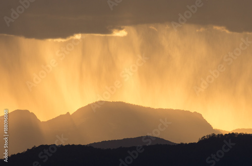 Canvas Print Setting sun behind a rain shower near Lijiang in Yunnan, China
