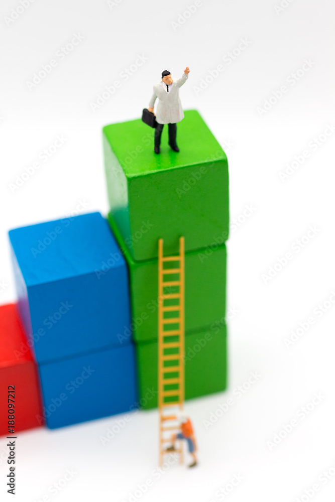 Miniature people: Businessmen take the climbing stairs on a colorful wooden building. Image use for get better position of work. Miniature people: Businessmen take the climbing stairs on a colorful wooden building. Image use for get better position of work.