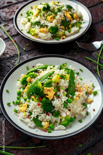 Fried rice with vegetables, broccoli, peas and eggs in a plate. healthy food