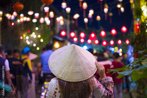 Canvas Print Tourist woman is wearing Non La (Vietnamese tradition hat) and enjoy sightseeing at Heritage village in Hoi An city in Vietnam