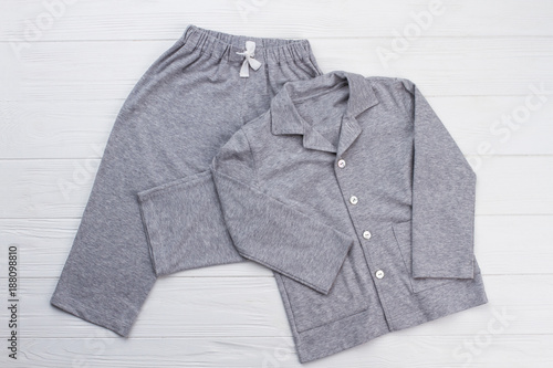 Sleepwear set on white background. Shirt and pants made of gray cotton fabric. Snugly fit and comfy pajama for boy.
