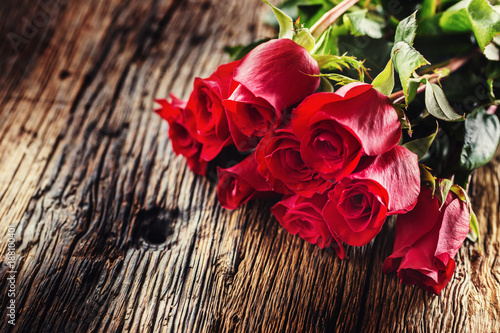 Fototapeta Naklejka Na Ścianę i Meble -  Red Roses. Bouquet of red roses free lying on rustic oak table