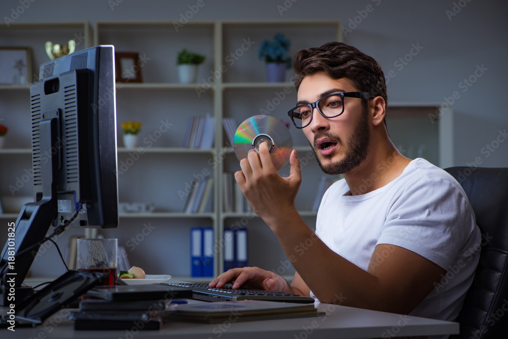 Young man staying late in office to do overtime work