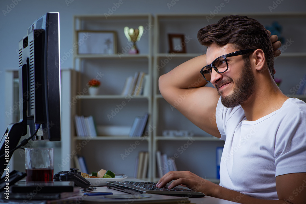 Young man staying late in office to do overtime work