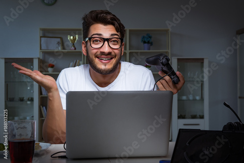 Young man playing games long hours late in the office