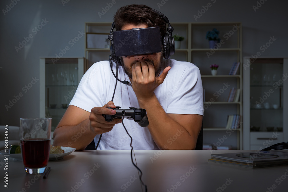 Young man playing games long hours late in the office Young man playing games long hours late in the office