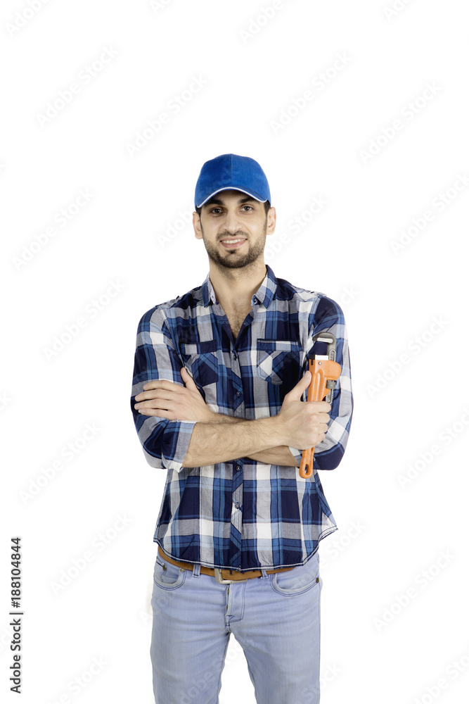 Confident plumber holding a wrench on studio Confident plumber holding a wrench on studio