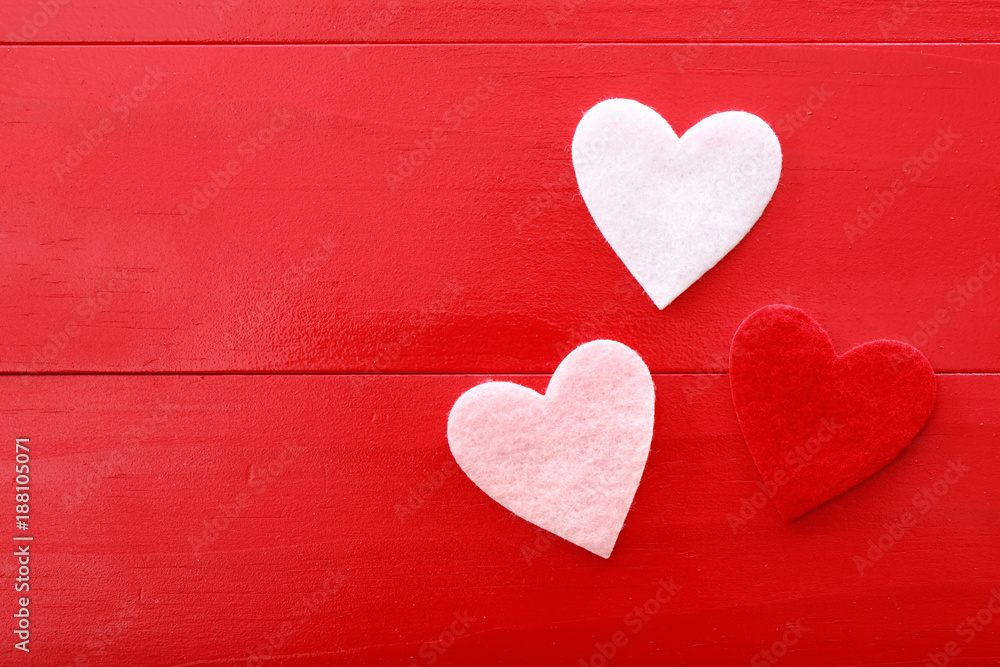 Felt hearts on a red wooden background Felt hearts on a red wooden background