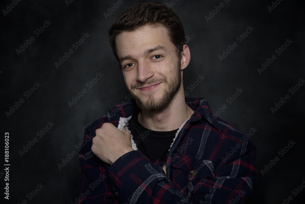 Portrait of a young man with a beard on a dark background. Portrait of a young man with a beard on a dark background.