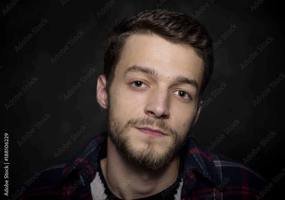 Portrait of a young man with a beard on a dark background. Portrait of a young man with a beard on a dark background.
