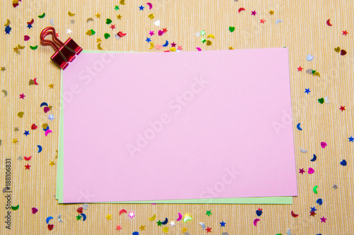 colourful sparlking stars, hearts and moons on pink paper and yellow background