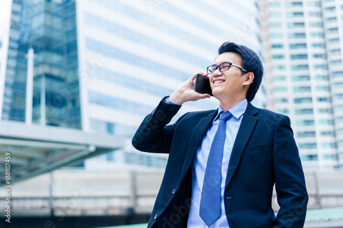 Closeup portrait of asian handsome business man using smartphone and smiling with happinest photo