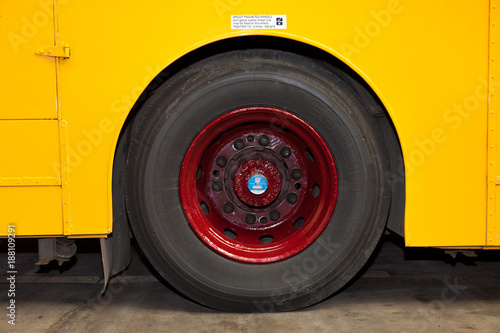 Red wheel and tyre on a yellow bus