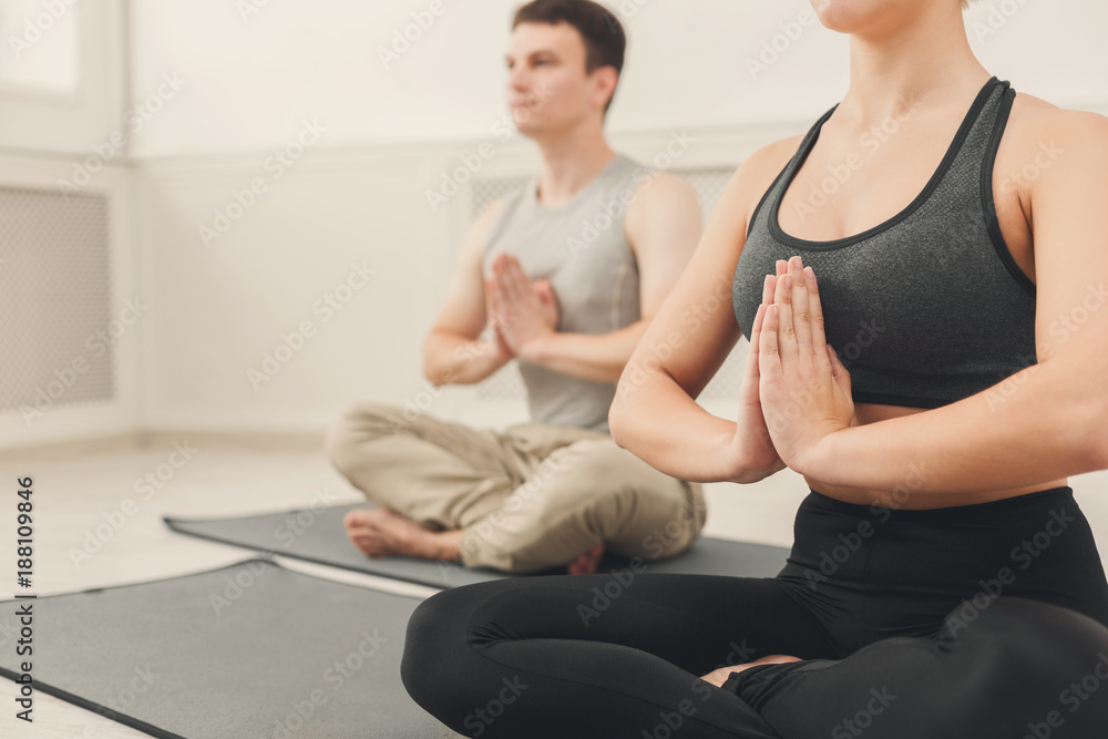 Young couple practicing yoga sitting in padmasana