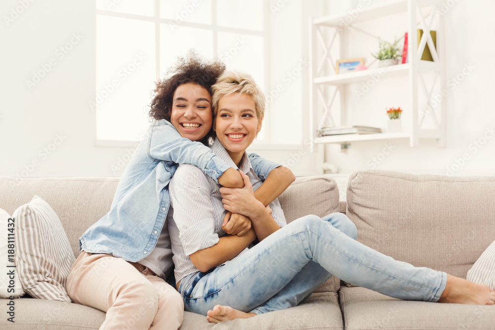 Two female friends embracing each other at home