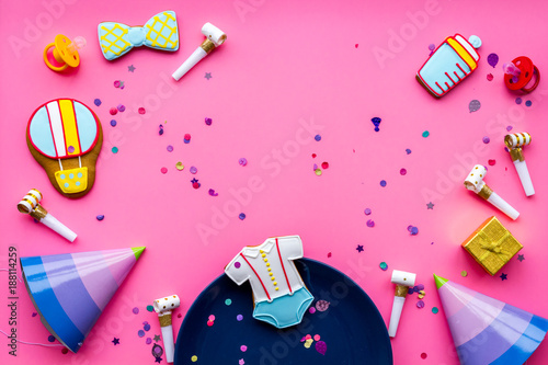 Baby shower. Cookies in shape of accesssories for child, party hats and confetti on pink background top view space for text