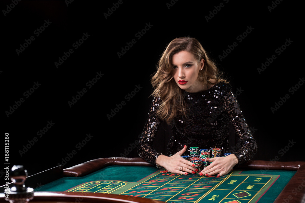Woman playing in casino. Woman stakes piles of chips playing rou Woman playing in casino. Woman stakes piles of chips playing rou