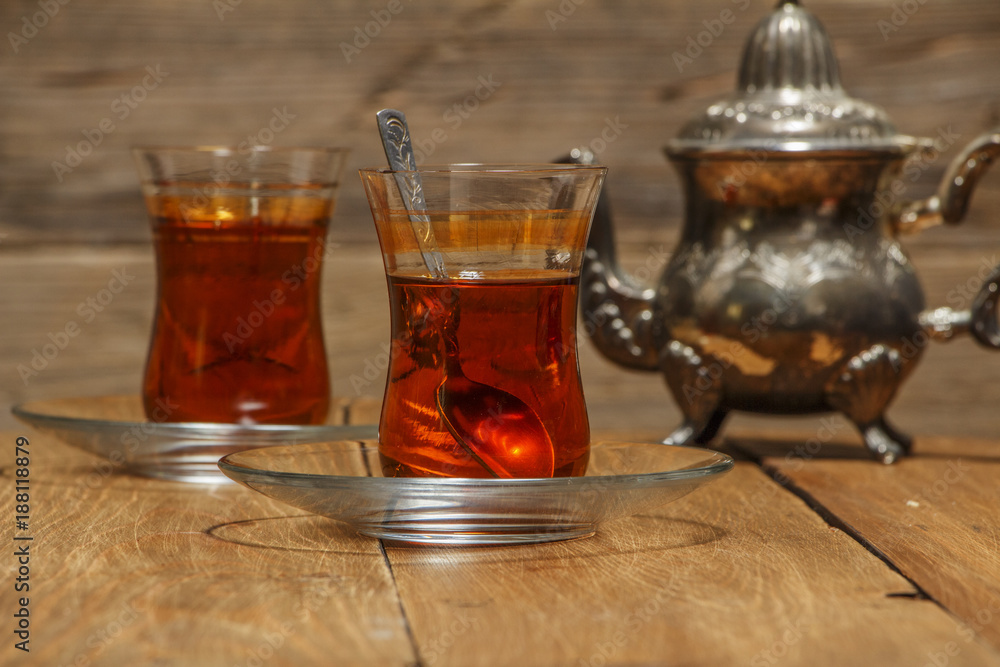 Turkish tea in traditional glass on a wooden table close-up.
