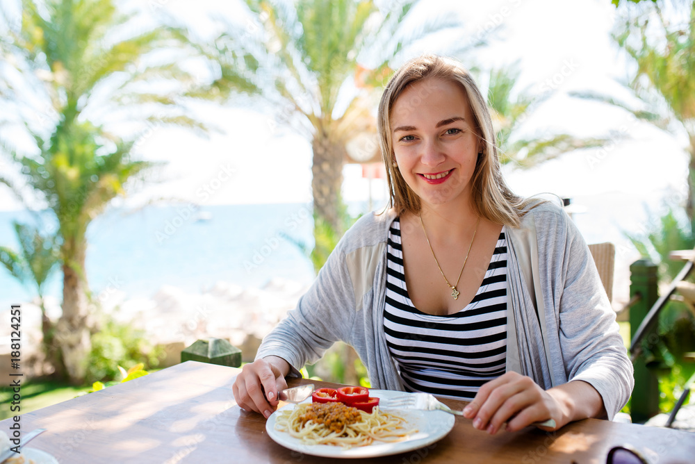 The girl is eating spaghetti at the seaside. The girl is eating spaghetti at the seaside.