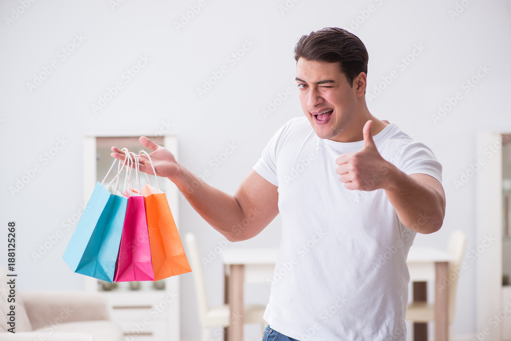Young man with gift bag at home preparing suprise for wife Young man with gift bag at home preparing suprise for wife
