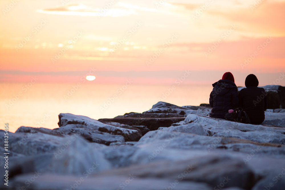 coppia di innamorati guarda il tramonto al mare
