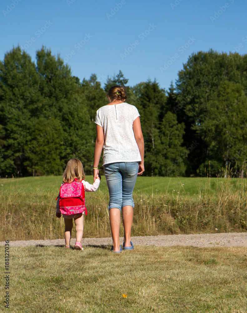 Fototapeta premium Flicka leder liten flicka hand i hand