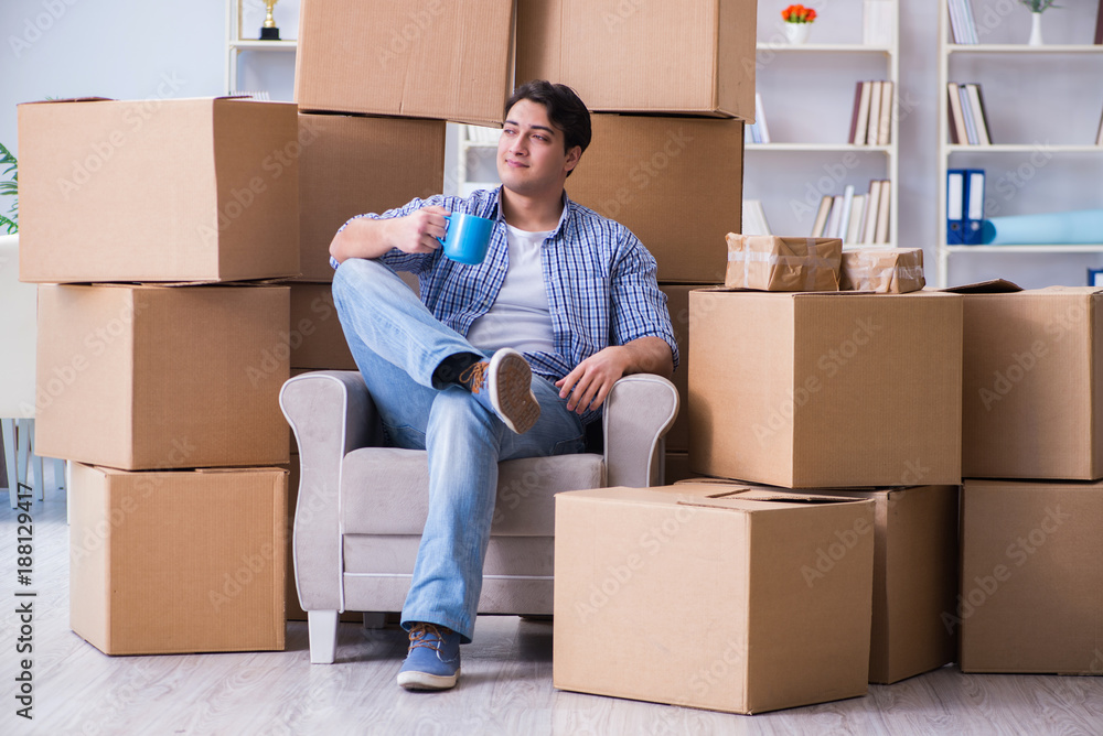 Young man moving in to new house with boxes Young man moving in to new house with boxes