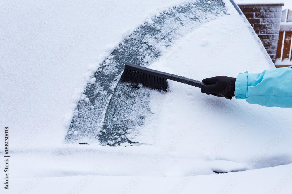 Woman cleaning snow from the car Woman cleaning snow from the car
