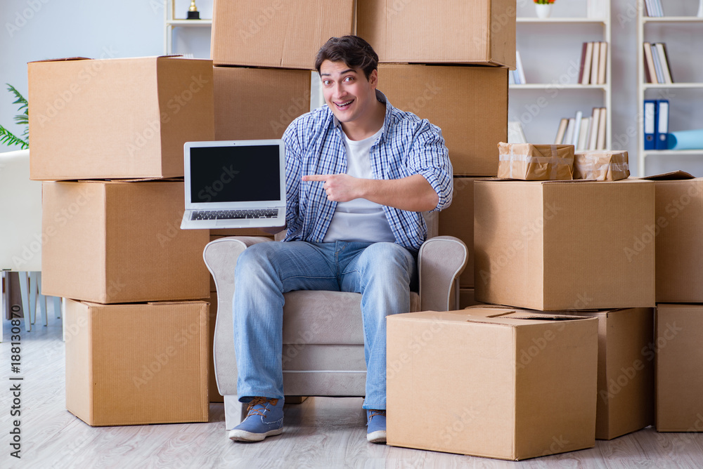 Young man moving in to new house with boxes Young man moving in to new house with boxes