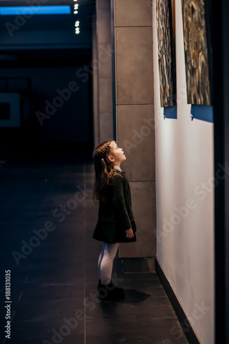 A little cute girl standing in the gallery