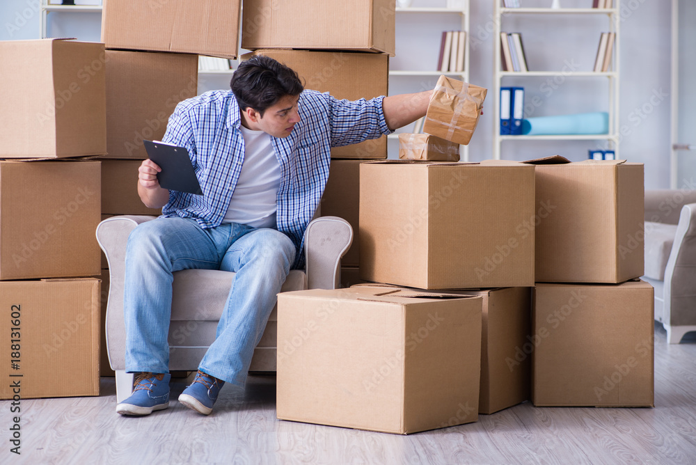 Young man moving in to new house with boxes Young man moving in to new house with boxes