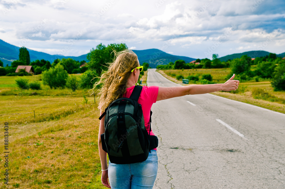 Young female hitchhiker by the road
