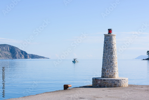 Beacon light with stone base, in Ermioni port near Nafplio, Greece. photo
