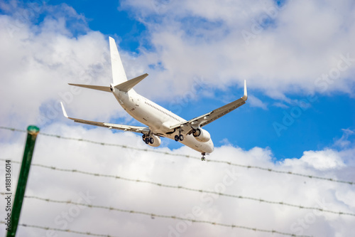 Flugzeug   ber Stacheldraht und blauem Himmel    