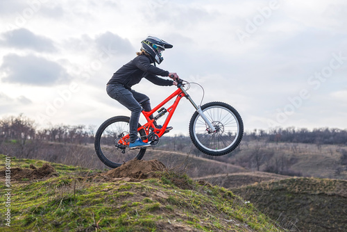 Professional rider is jumping on the bicycle  with background of blue sky. Sunny summer day.