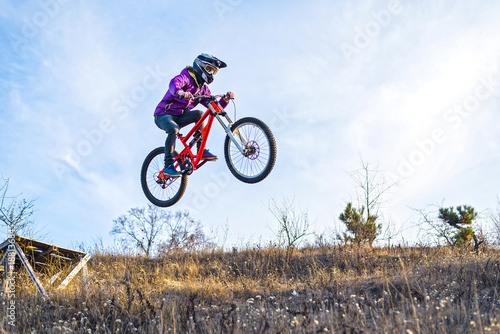 Сyclist is jumping from a high springboard, the sky and free space for your text.