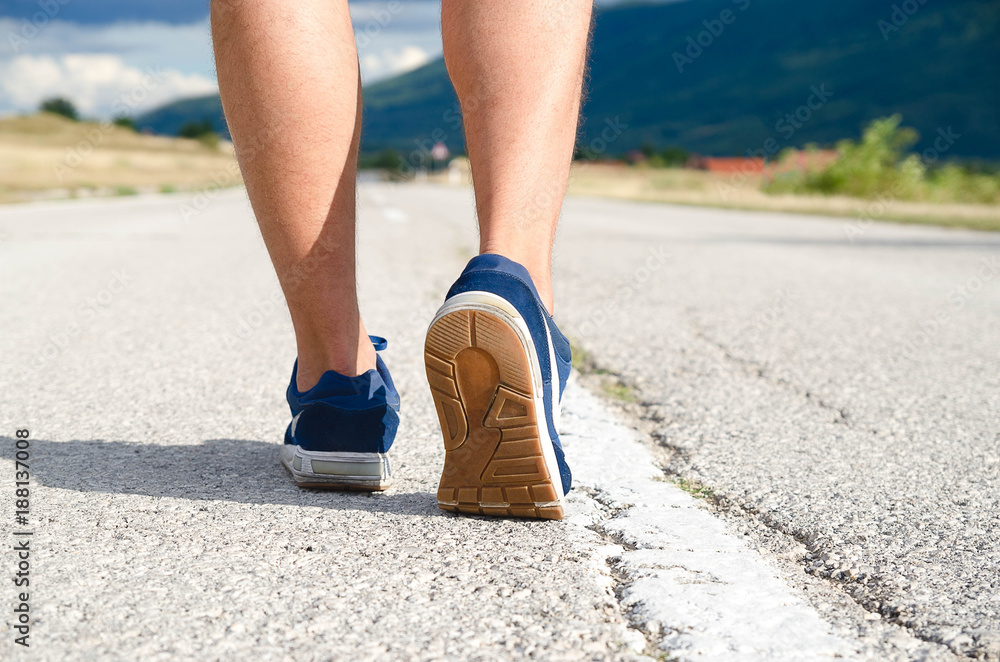 Back side view close up shot of feet with running shoes on the road. Sport and healthy lifestyle concepts. Back side view close up shot of feet with running shoes on the road. Sport and healthy lifestyle concepts.