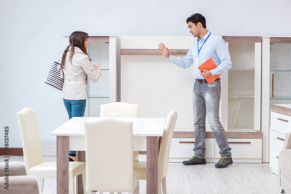 Fototapeta premium Salesman explaining to woman customer at furniture store