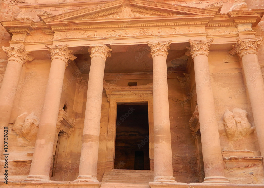 The lower level of Al-Khazneh Treasury temple facade in Petra, Jordan, with the pediment supported by columns, sculptures of the twins Castor and Pollux and the central doorway
