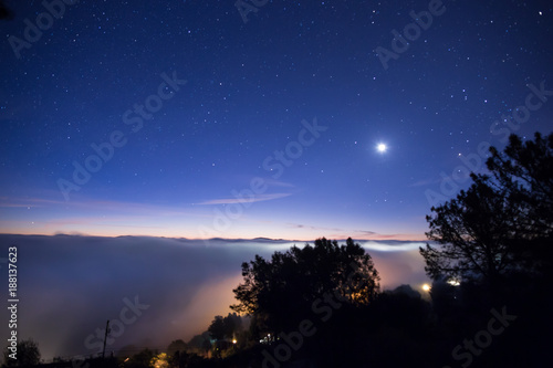 Night Sky and the Moon Above Foggy Landscape