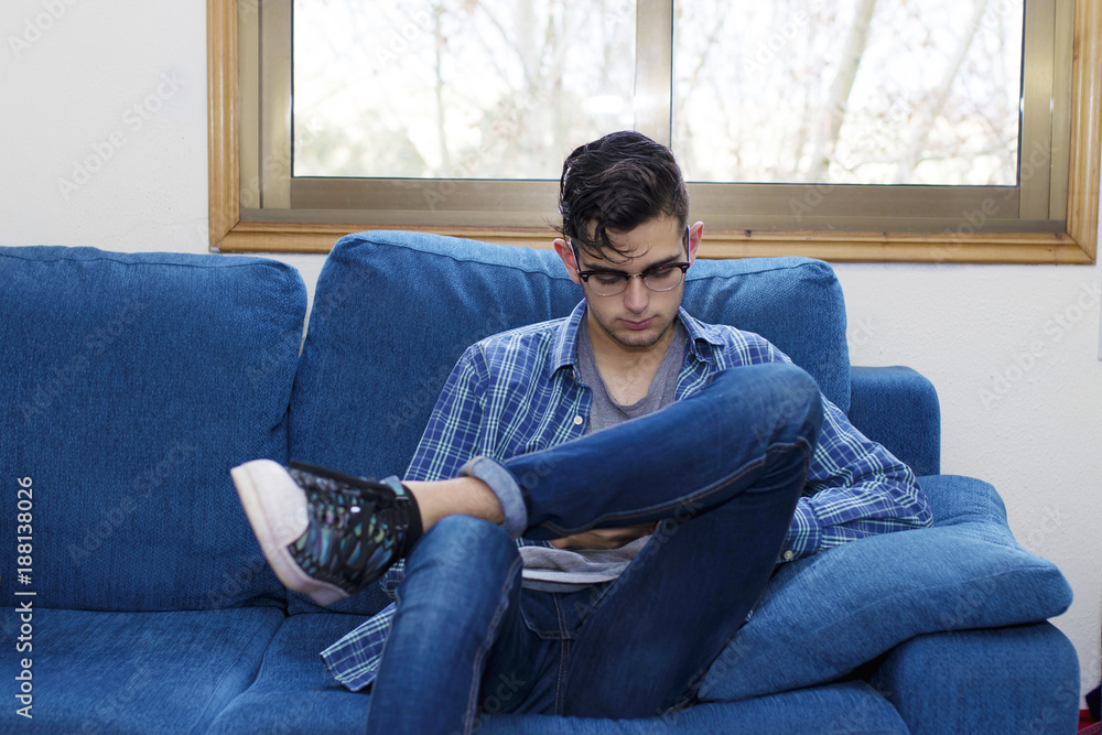 Obraz premium young man in the home sofa with mobile phone