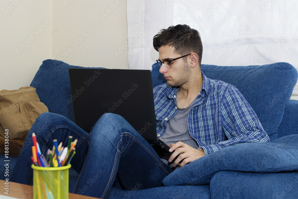 young in the home sofa with mobile phone and laptop