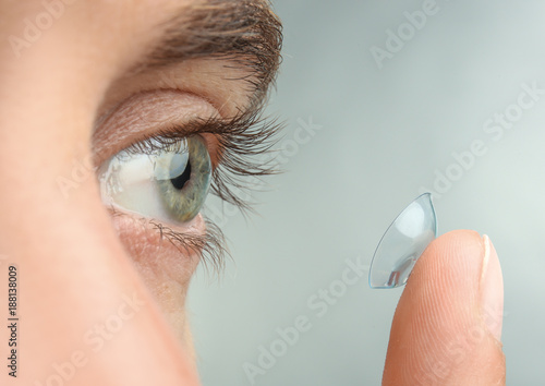 Photos Young man putting contact lens in his eye, closeup