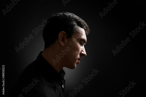 Serious young man on black background © Africa Studio