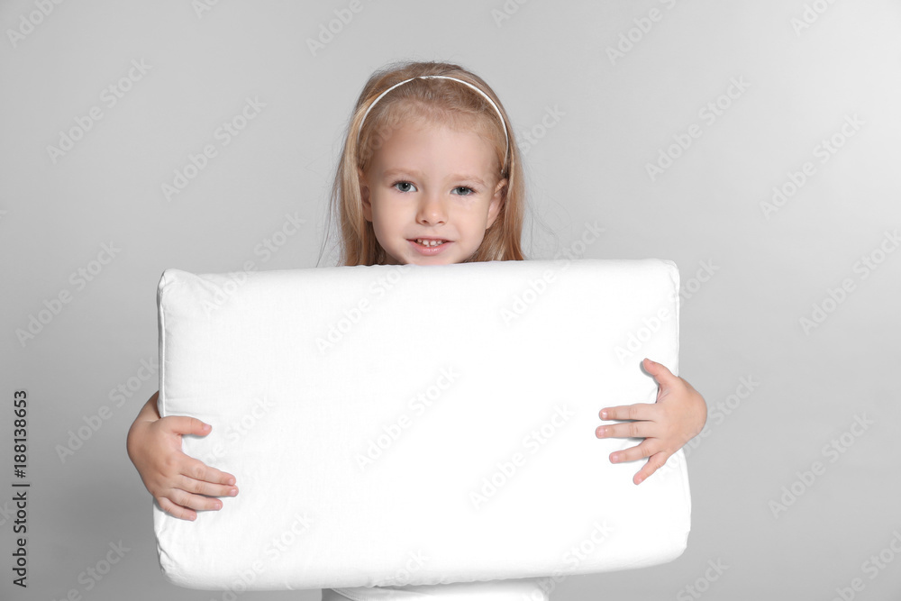 Little girl with big pillow on grey background Little girl with big pillow on grey background